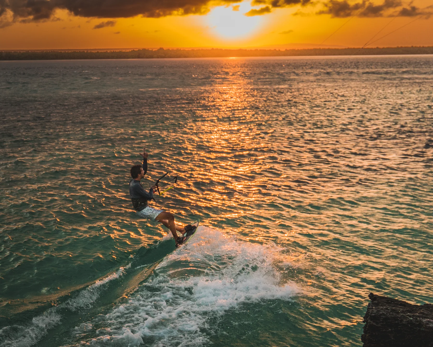 Kitesurfer fährt im goldenen Abendlicht vor der Küste von Watamu